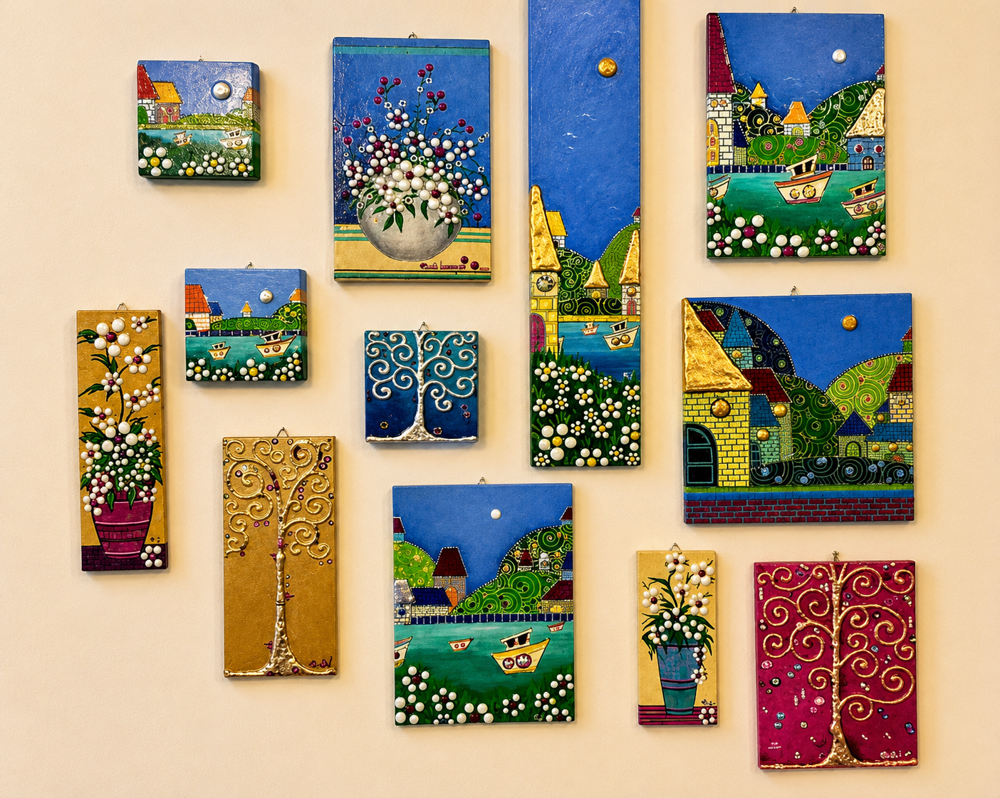 Parete con una selezione di paesaggi, fiori e alberi dipinti